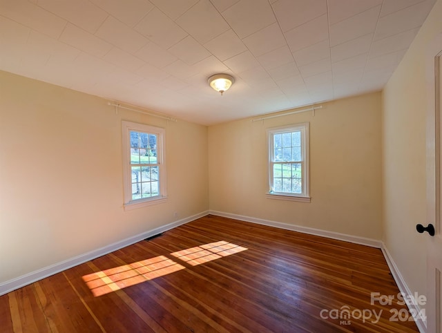 unfurnished room with dark wood-type flooring and a healthy amount of sunlight