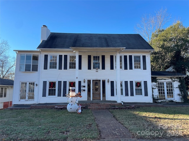 colonial-style house featuring a front yard