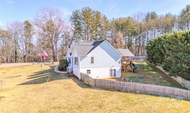 view of home's exterior with a lawn and a playground