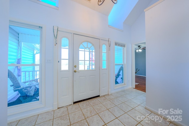 tiled foyer featuring high vaulted ceiling