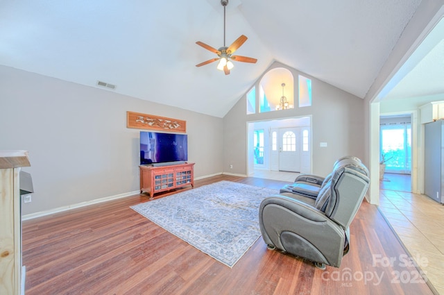 living room with ceiling fan, high vaulted ceiling, and light hardwood / wood-style flooring