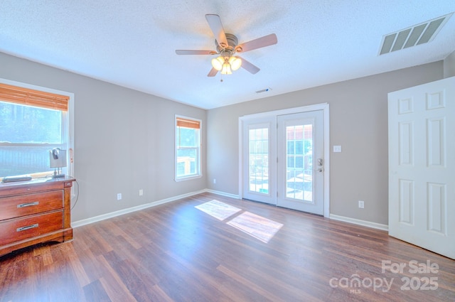 empty room featuring ceiling fan, dark hardwood / wood-style floors, and a textured ceiling