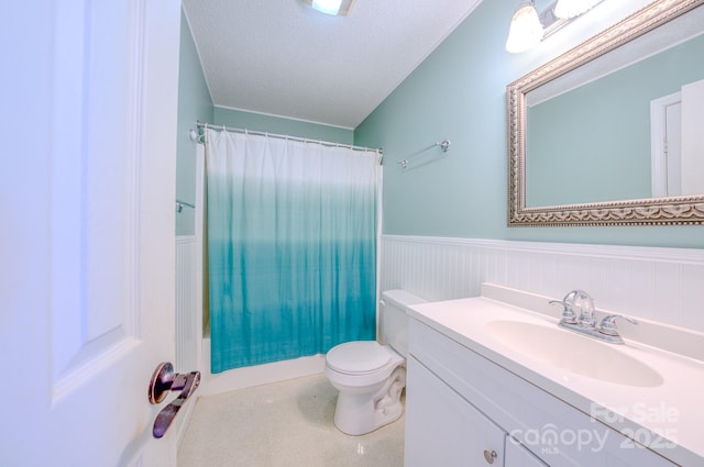 full bathroom featuring shower / bathtub combination with curtain, vanity, a textured ceiling, and toilet