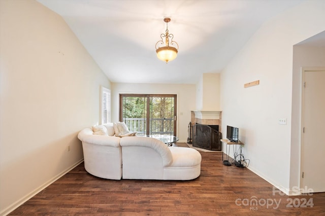 living room featuring a tiled fireplace, dark wood-type flooring, and lofted ceiling