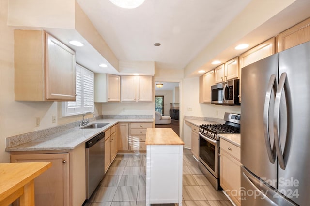 kitchen featuring wood counters, appliances with stainless steel finishes, light brown cabinetry, a wealth of natural light, and sink