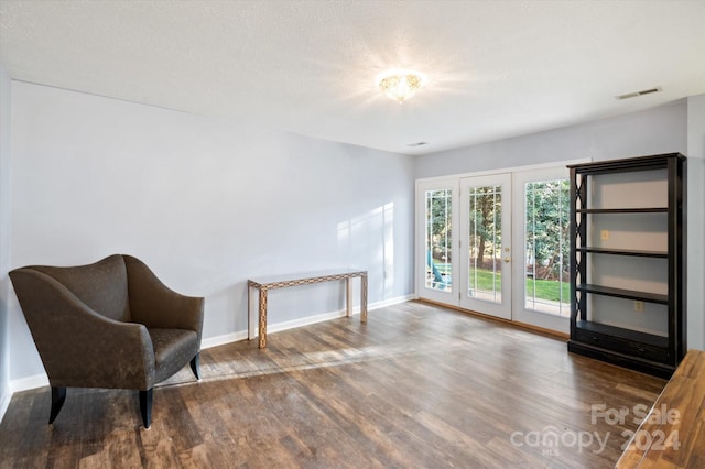 sitting room featuring a textured ceiling, french doors, and dark hardwood / wood-style floors