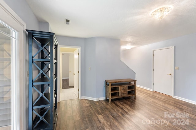 unfurnished room with a textured ceiling and dark hardwood / wood-style floors