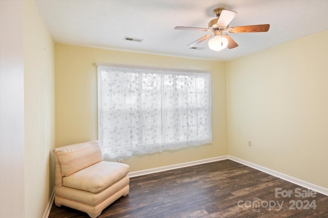 sitting room with ceiling fan and dark wood-type flooring