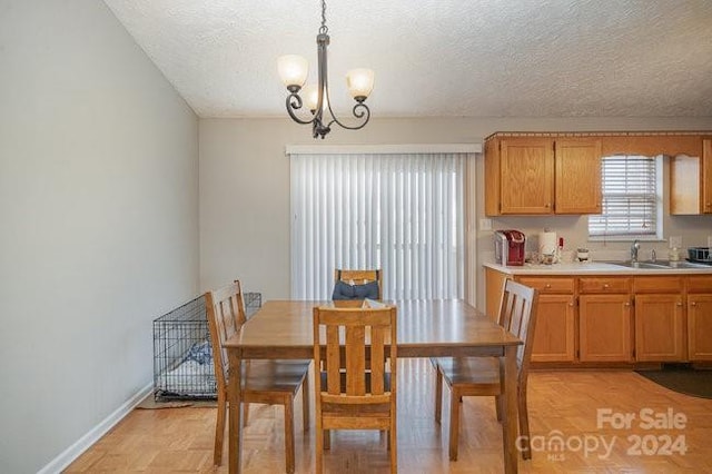 dining room with a chandelier, a textured ceiling, and sink