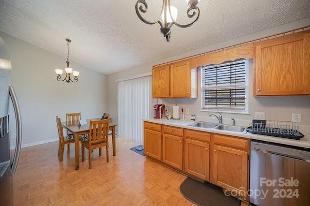 kitchen featuring sink, vaulted ceiling, appliances with stainless steel finishes, decorative light fixtures, and a chandelier