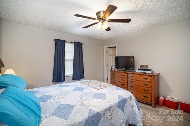 carpeted bedroom with ceiling fan and a textured ceiling