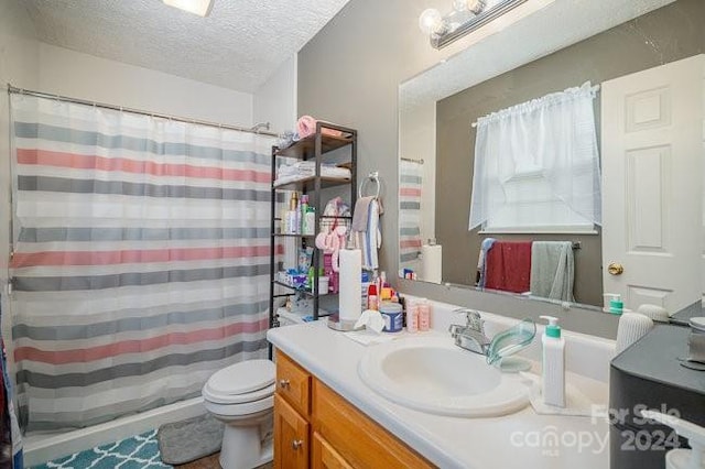 bathroom featuring curtained shower, vanity, a textured ceiling, and toilet