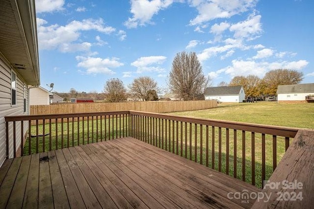 wooden deck featuring a lawn