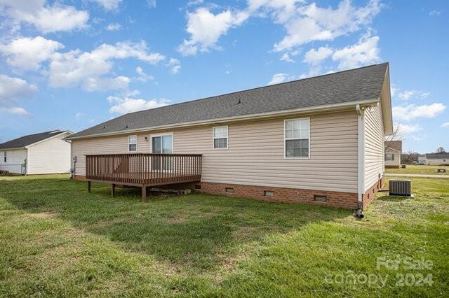 rear view of house featuring central air condition unit, a yard, and a deck