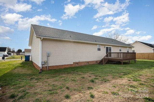 rear view of property with a yard and a wooden deck