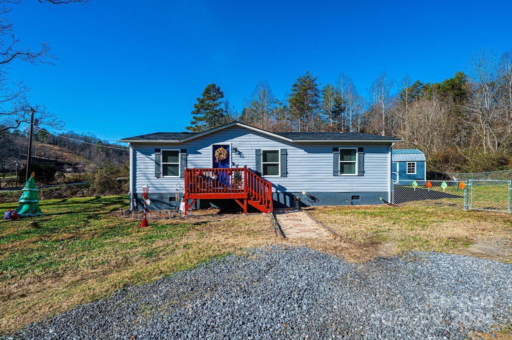 manufactured / mobile home with a deck and a front yard