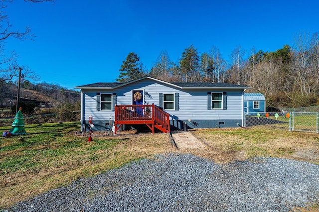 manufactured / mobile home with a deck and a front yard