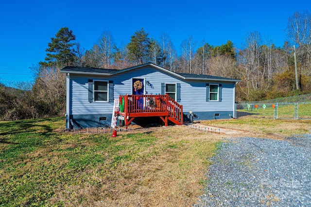 view of front of house featuring a wooden deck and a front yard