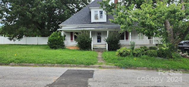 view of front of house with a porch and a front yard