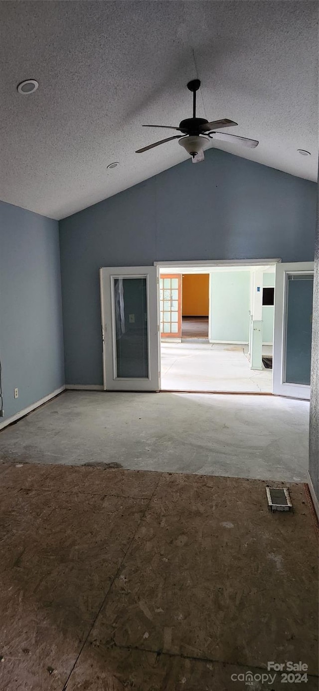 unfurnished living room with ceiling fan, lofted ceiling, and a textured ceiling