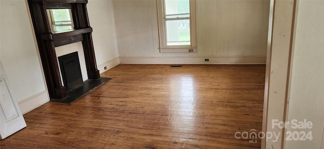 unfurnished living room featuring wood-type flooring and a wealth of natural light