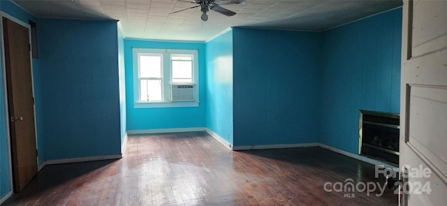 unfurnished room featuring dark hardwood / wood-style flooring, cooling unit, ceiling fan, and ornamental molding