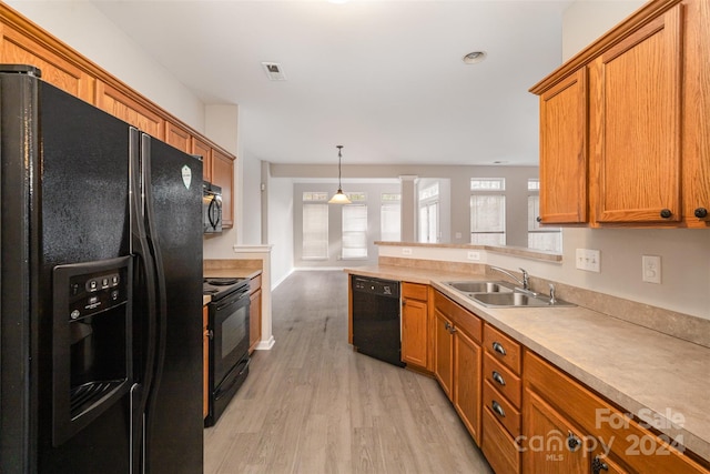 12039 Windy Rock Way, Charlotte, NC 28273 - kitchen with hanging light fixtures, sink, black appliances, and light hardwood / wood-style floors