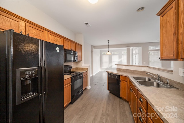 12039 Windy Rock Way, Charlotte, NC 28273 - kitchen with pendant lighting, sink, black appliances, and wood-type flooring