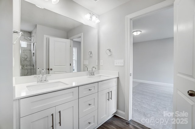 bathroom with hardwood / wood-style floors, an enclosed shower, and vanity