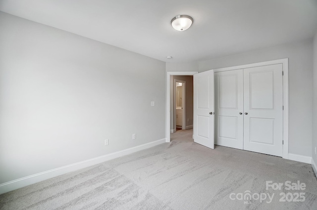 unfurnished bedroom featuring light colored carpet and a closet