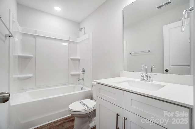 full bathroom with bathtub / shower combination, toilet, vanity, and hardwood / wood-style floors