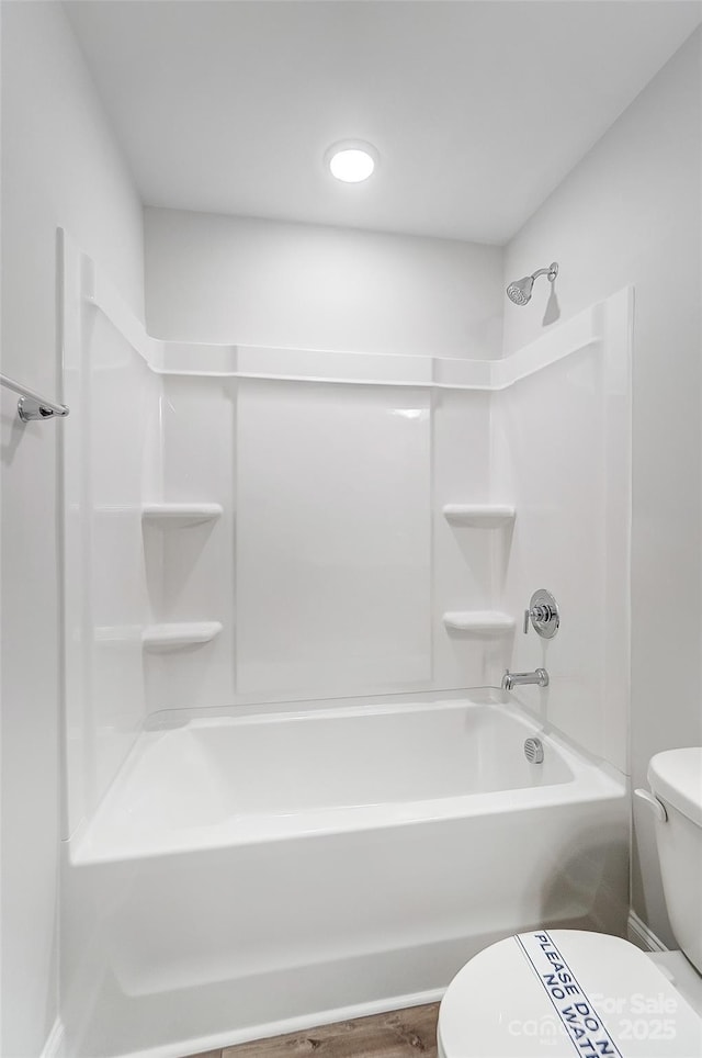 bathroom with wood-type flooring, toilet, and washtub / shower combination