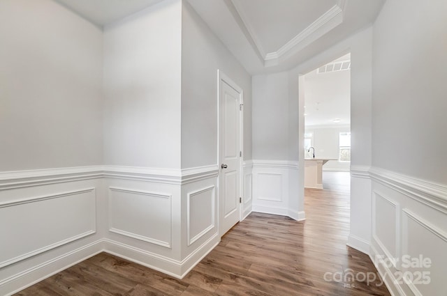 hall with sink, hardwood / wood-style floors, and crown molding