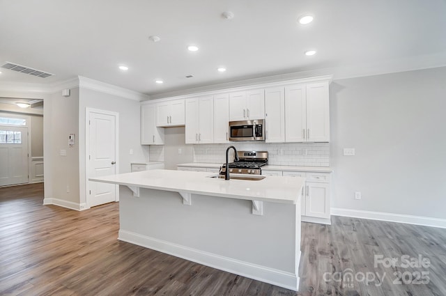 kitchen featuring white cabinetry, a center island with sink, and appliances with stainless steel finishes