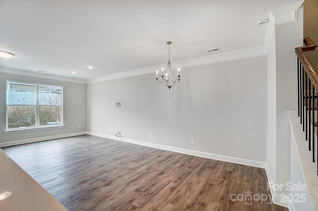 empty room with wood-type flooring, ornamental molding, and a notable chandelier