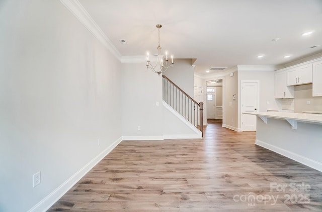 unfurnished living room featuring crown molding, a notable chandelier, and light wood-type flooring