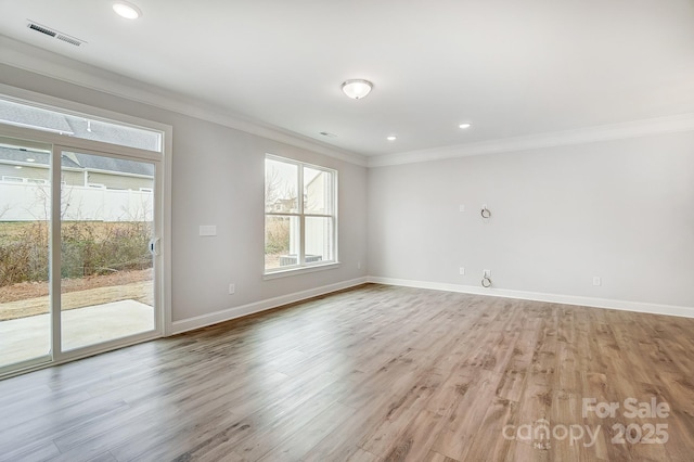 spare room with light hardwood / wood-style floors and crown molding