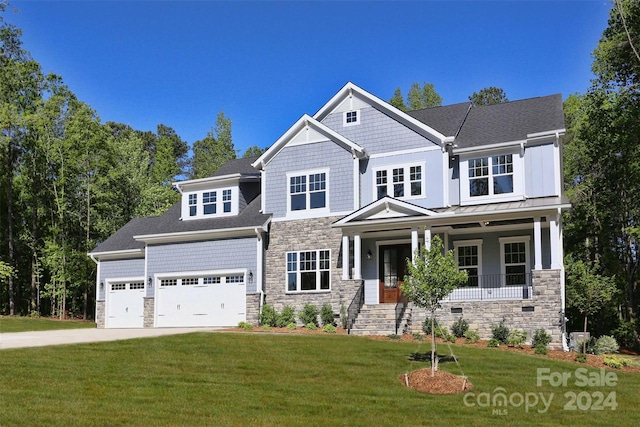 craftsman-style home featuring a porch, a garage, and a front lawn