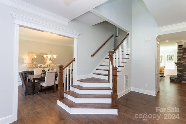 stairs with hardwood / wood-style flooring, crown molding, and an inviting chandelier