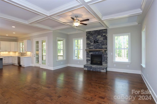 unfurnished living room with a fireplace, a wealth of natural light, dark hardwood / wood-style flooring, and ornamental molding