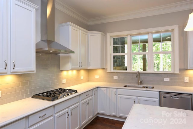 kitchen with white cabinets, wall chimney range hood, sink, and stainless steel appliances