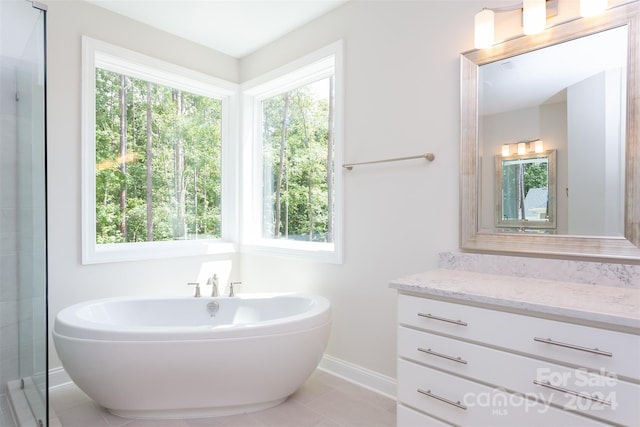 bathroom with tile patterned flooring, vanity, and a washtub