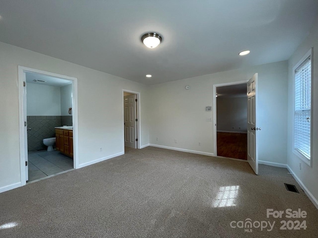 unfurnished bedroom with light colored carpet and ensuite bath