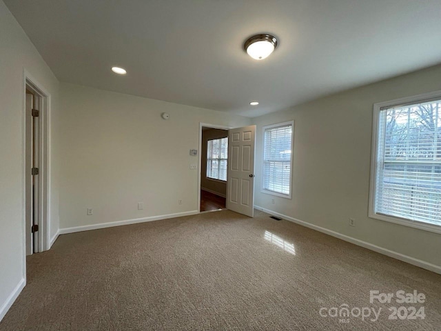 spare room featuring dark colored carpet