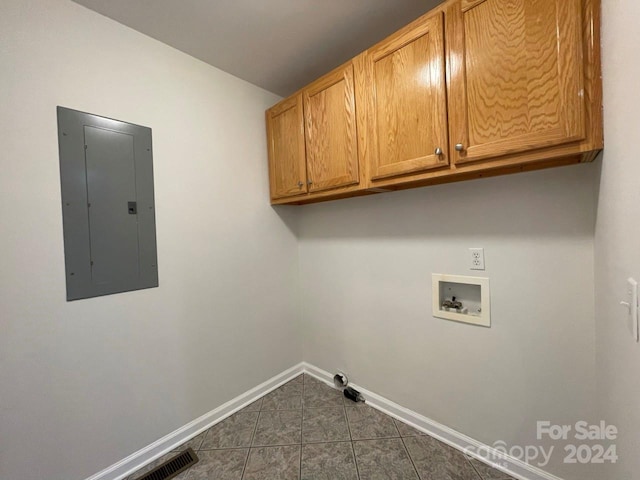 laundry room featuring cabinets, hookup for a washing machine, electric panel, and dark tile patterned flooring