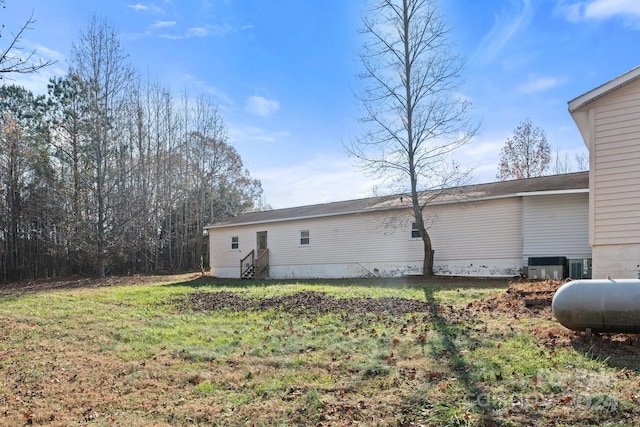 view of property exterior with a yard and central AC