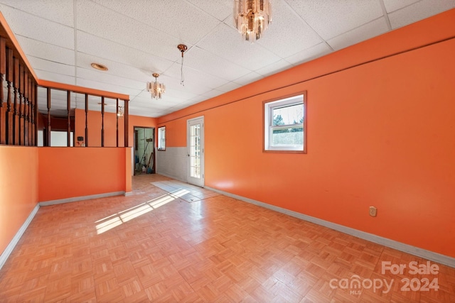 unfurnished room featuring a drop ceiling and parquet flooring