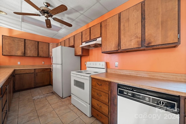 kitchen featuring light tile patterned floors, white appliances, a drop ceiling, and ceiling fan