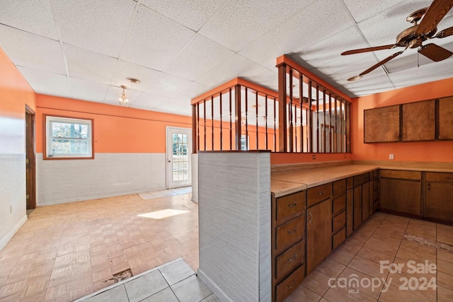 kitchen featuring a wealth of natural light, a drop ceiling, and ceiling fan