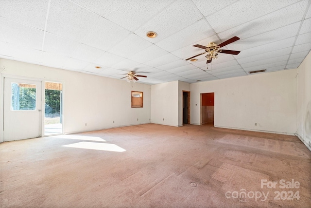 carpeted spare room with a drop ceiling and ceiling fan